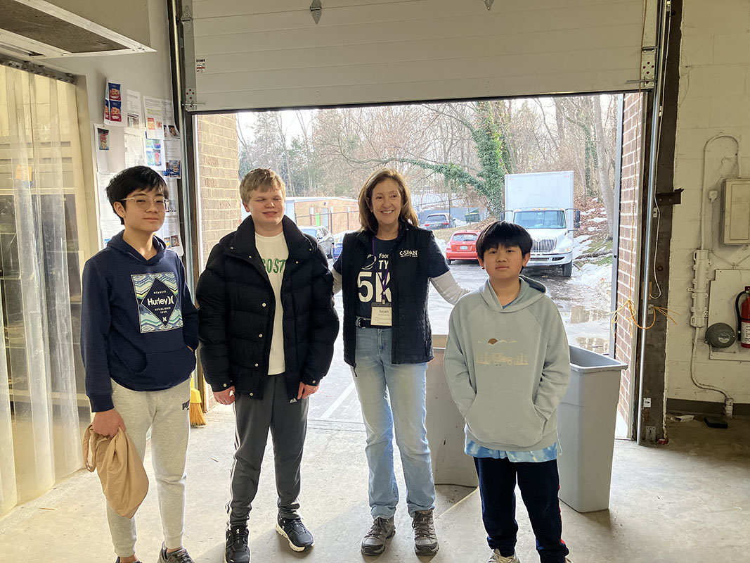 Student volunteers with a community food-bank staff member