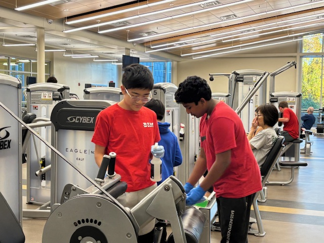 Student volunteers helping clean recreation center equipment