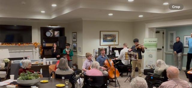 Young musicians performing for senior community members